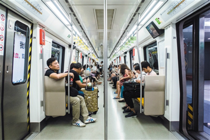 Students play online games inside a subway train in Beijing